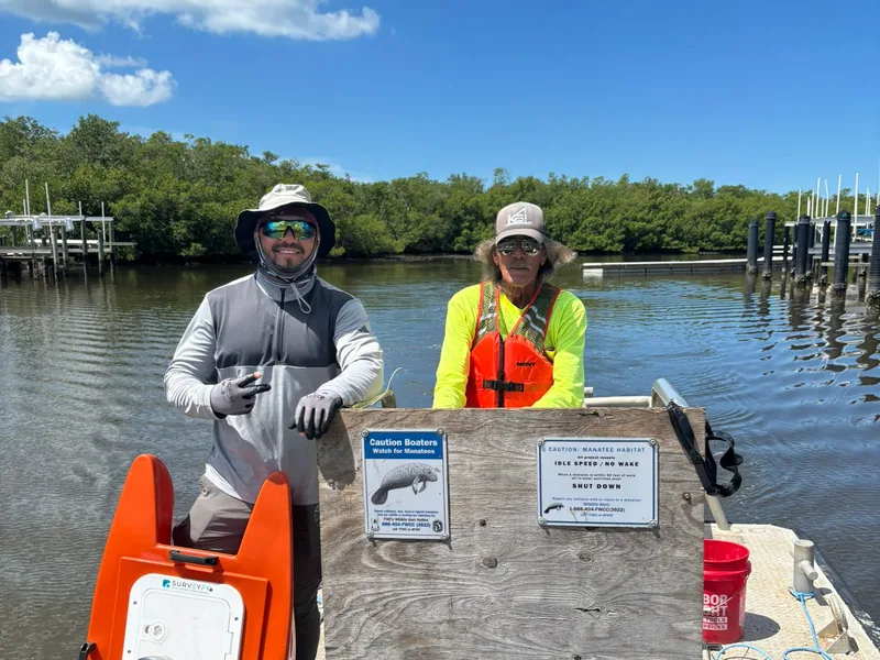 Two SurveyFy crew members aboard the survey boat with the unmanned bathymetric vessel