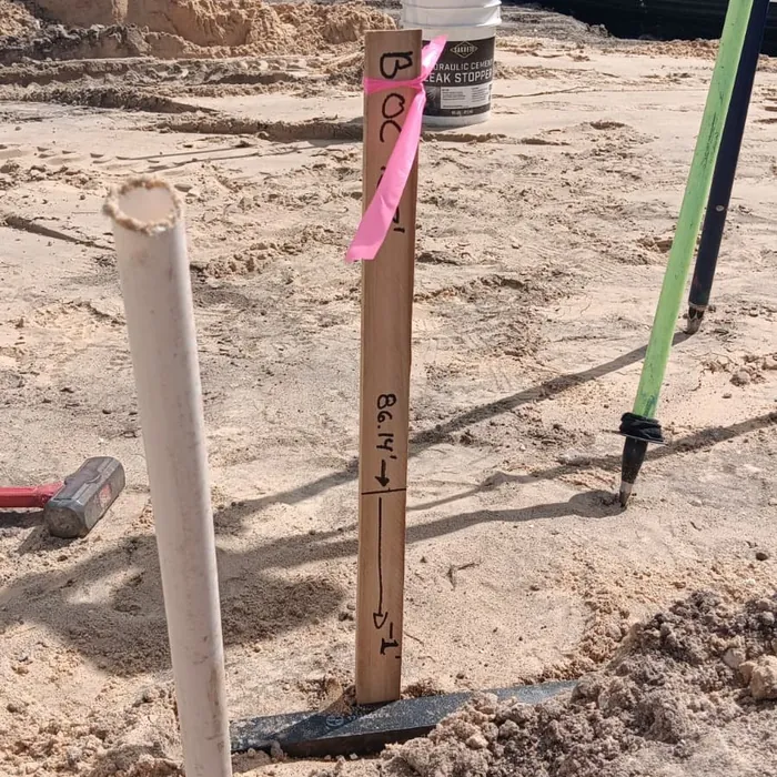 Survey stakes with pink flagging set at a lot corner in Florida