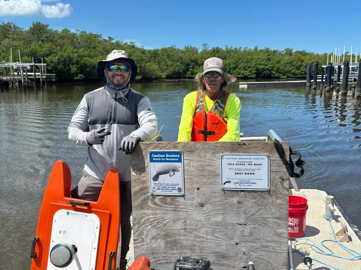 Two SurveyFy surveyors on a boat with the hydrographic drone on a Florida waterway
