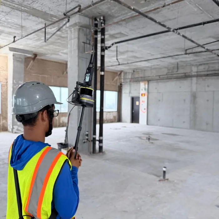 SurveyFy surveyor scanning the interior of a building under construction with a mobile LiDAR scanner
