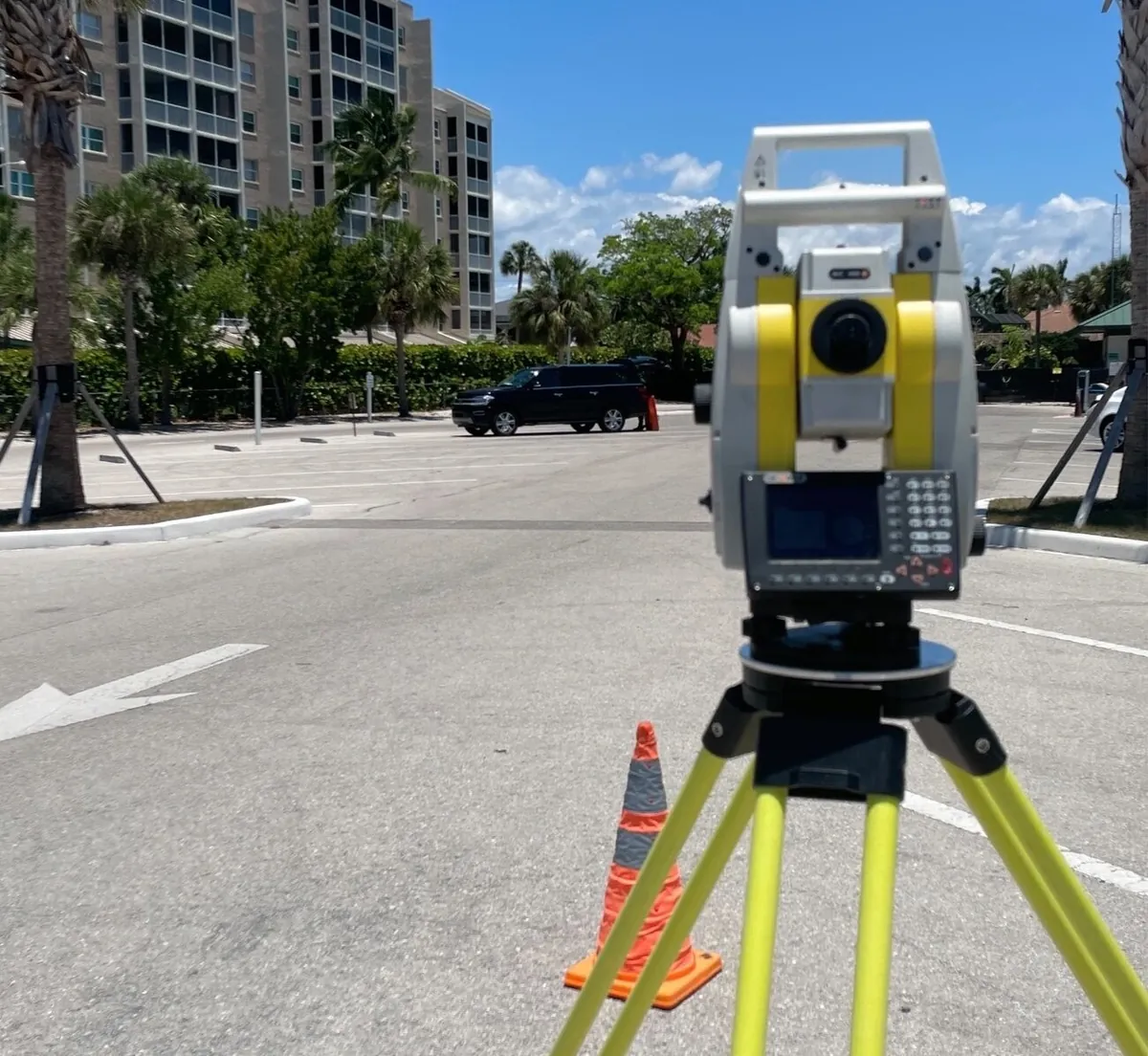 Surveyor with a total station in front of a building