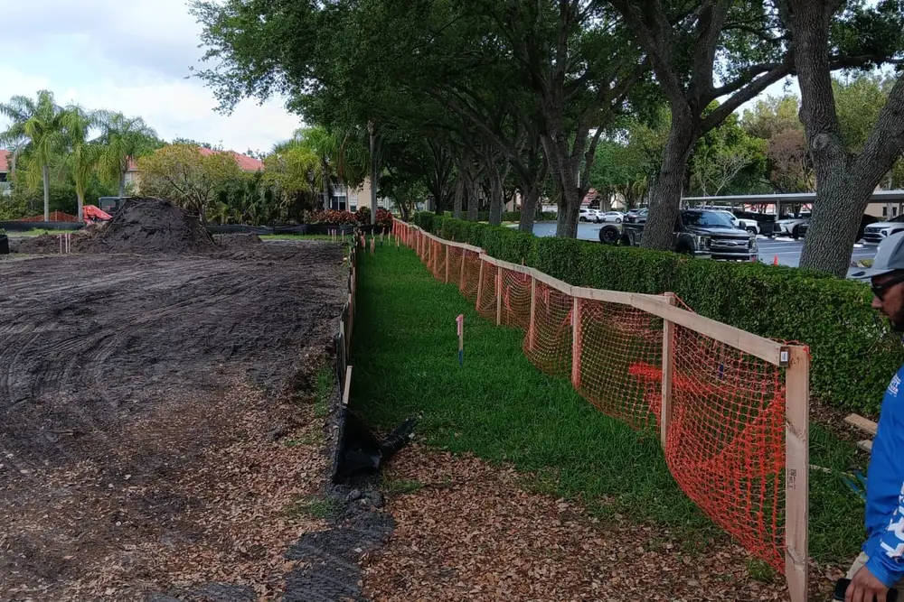 Trees protected with an orange barrier on a permitted construction site in Florida